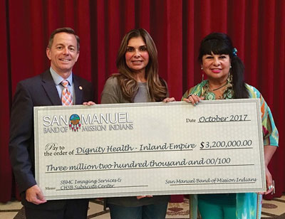 Representatives from both groups hold up a check showing the amount of the grant.