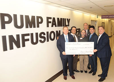 A group holds a check showing the donation amount at the Pump Family Infusion Center