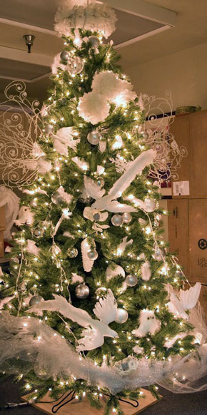 A Christmas tree, decorated with white lights, tulle, and dove ornaments