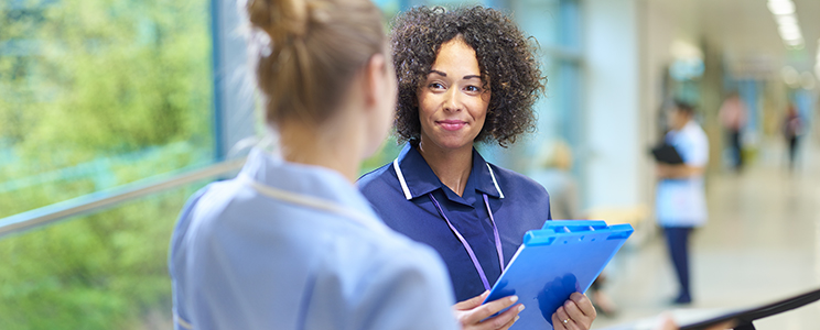 Health care workers talking in a hallway.