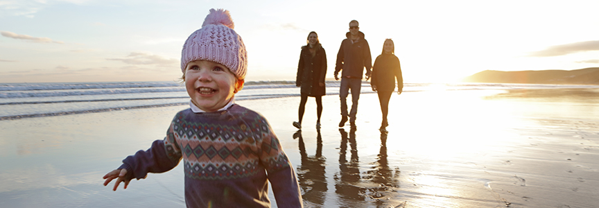Smiling young boy running on beach